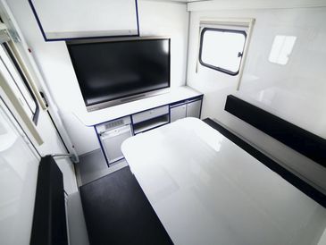 Innenraum eines Einsatzleitwagens mit Bildschirm und Sitzbänken